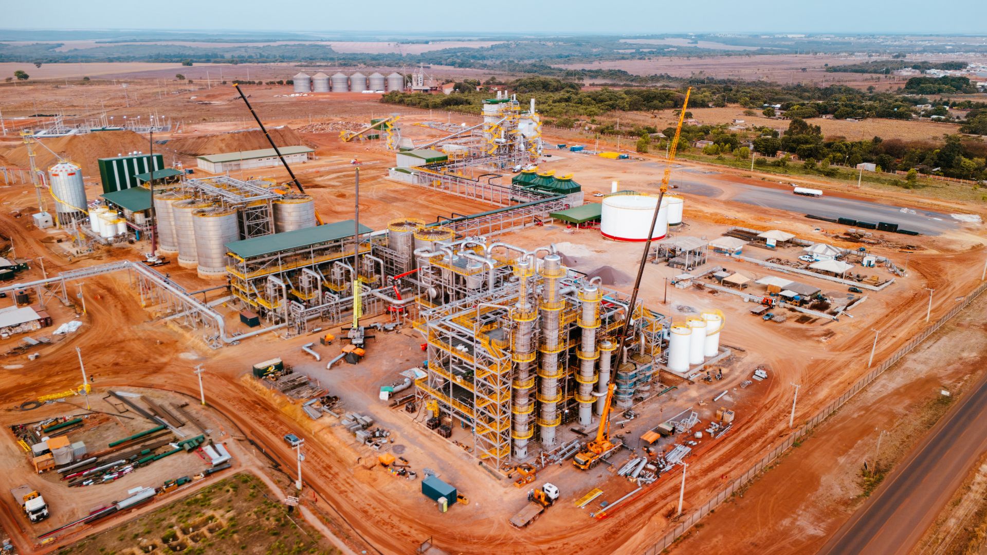 Vista noturna da planta industrial da Alvorada Bioenergia. A iluminação destaca as torres de destilação e o complexo de secagem de DDGS — estruturas que operam 24 horas por dia.